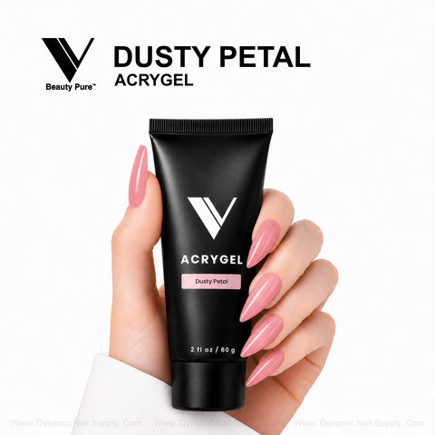A hand with long pink nails holds a Dusty Petal - V Beauty Pure AcryGel tube for salon-quality nail enhancements.