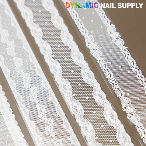 Five rolls of White Mixed Design Nail Foil 4 with intricate lace patterns shown on a brown background.