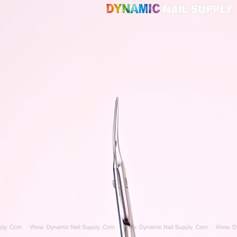 NT1246 Silver Premium Curved Tip Cuticle Scissors shown vertically against a soft pink background.