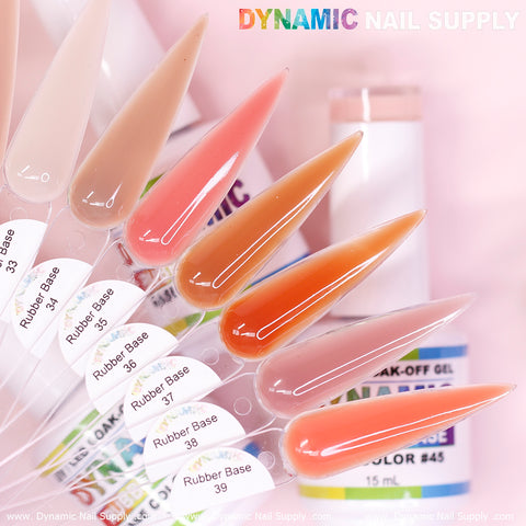 A lineup of seven elongated nail polish samples from the (BIAB) Rubber Base gel collection, numbered 33 to 39, presents a gradient of colors ranging from beige to deep orange. In the background, a partially visible bottle hints at the collection's elegance. Above it all, "Dynamic Nail Supply" is prominently displayed in vibrant letters.