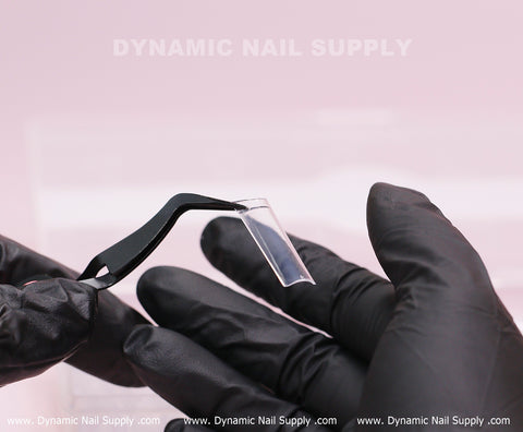 A gloved hand holds XL Square Nail Tips (Not C-Curve) with tweezers on pink; Dynamic Nail Supply text above.