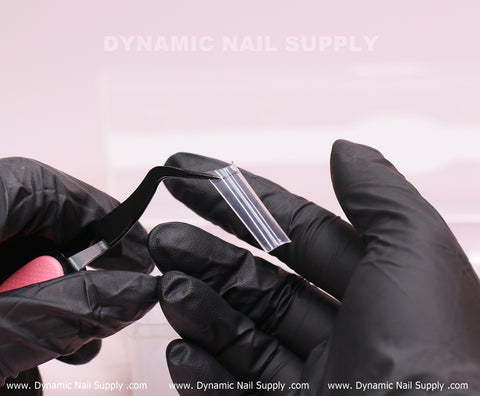 Gloved hands use tweezers to hold XL Square Nail Tips—Extra Long, Straight Shape by DYNAMIC NAIL SUPPLY.
