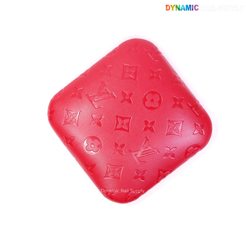 A red LV engrave elbow pad for nail techs, square, floral embossed, soft PU leather, viewed from above on white.