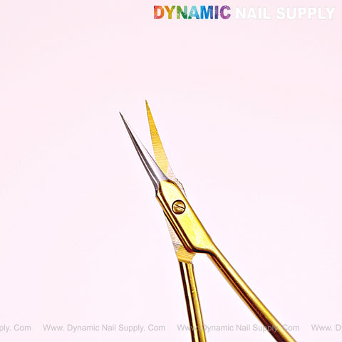 NT1245 Gold Premium Curved Tip Cuticle Scissors with stainless steel curved tips shown on pale pink, Dynamic Nail Supply above.