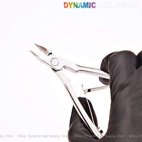 A black-gloved hand holds NT1221 - G06 7mm Professional Stainless Steel Cuticle Nippers on a white background.