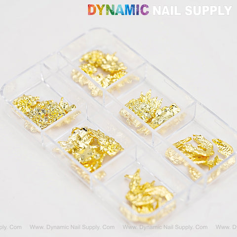 A clear case holds Gold Flowers and Wings Charms for Nail Art DIY Designs with foil pieces, shown on a white background.