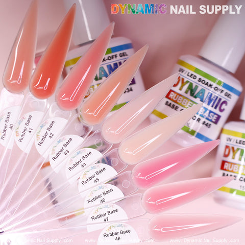 A collection of elongated nail swatches showcasing a gradient from pink to peach is labeled with numbers 40 to 48 and features the (BIAB) Rubber Base Gel. In the background, bottles of Dynamic Nail Supply's Nails Gel Polish create an eye-catching display of vibrant colors and a trusted brand.