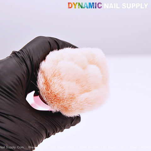 A gloved hand holds the [Metal Pink] Rose Nail Dust Cleaner Brush for Cleaning Dust Dip Powder; logo shown above.