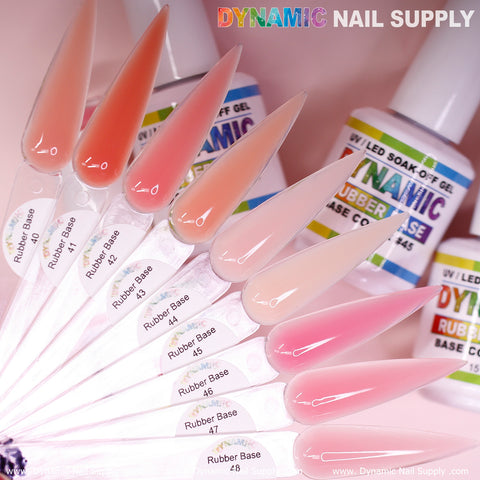 A captivating array of nail swatches in pink and peach tones, each labeled as part of the (BIAB) Rubber Base Gel (Builder Gel in a Bottle) Number 40 to 48 collection, is prominently displayed. In the background, bottles of Dynamic Nail Supply’s UV LED Soak Off Nails Gel Polish highlight the vivid colors and extensive brand options available for nail enthusiasts.