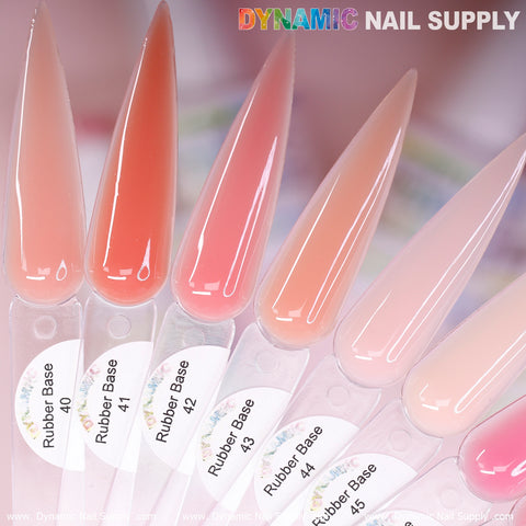 A set of nine elongated BIAB Rubber Base Gel swatches from the Number 40 to 48 collection by Dynamic Nail Supply is elegantly arranged on a pink background. These hues, ranging from soft pinks to vibrant corals, showcase the beauty of this Builder Gel in a Bottle collection.