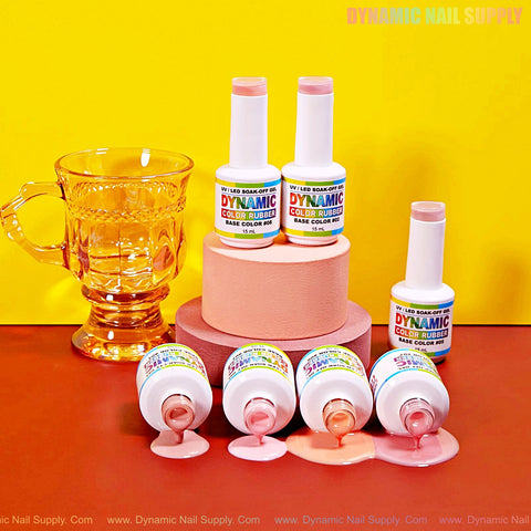 Five bottles of (BIAB) Rubber Base Nude Color Builder Gel Polish 01-12, some spilled, by a yellow cup on a pink pedestal.