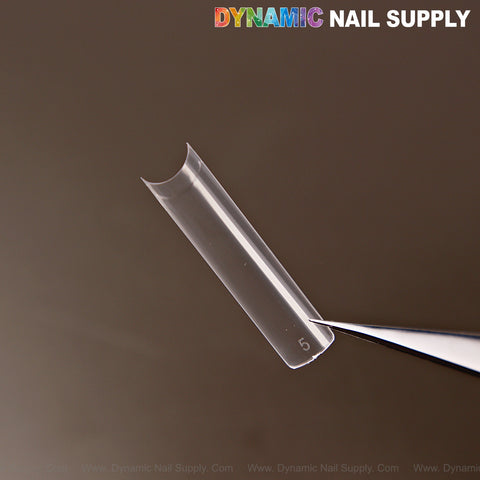 An XXL Ultra Thin Square Nail Tip (Not C-Curve) from a 504pcs set, held by tweezers, DYNAMIC NAIL SUPPLY at top right.