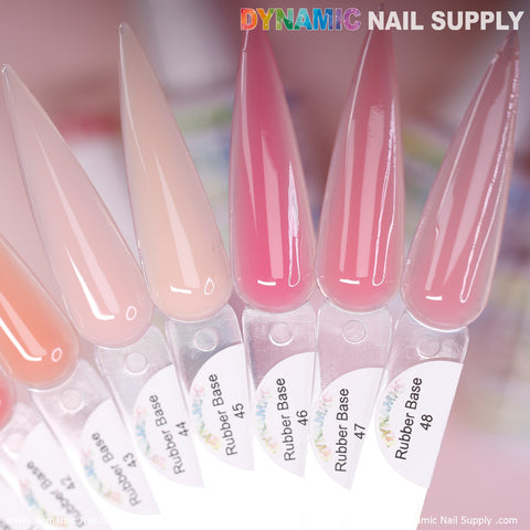 Close-up of six nail polish color samples in elongated shapes ranging from light nude to deep pink, highlighting the versatility of the (BIAB) Rubber Base Gel collection by Dynamic Nail Supply. Each sample is labeled with a number from 44 to 48 against a gently blurred background, with "Dynamic Nail Supply" elegantly displayed at the top.