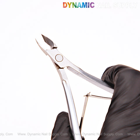 A gloved hand holds NT1222 - G07 5mm Professional Stainless Steel Cuticle Nippers against a white background.