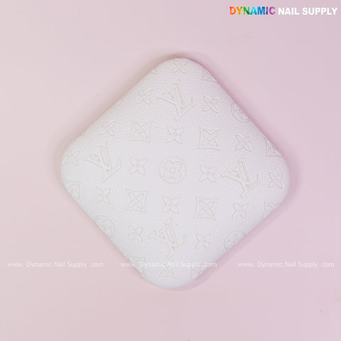 White LV Engrave-Grain nail tech elbow rest pad in textured PU leather, perfect for long hours, on pastel pink background.