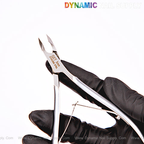 A gloved hand holds the NT1222-G07 5mm Professional Stainless Steel Cuticle Nippers for precise nail care.