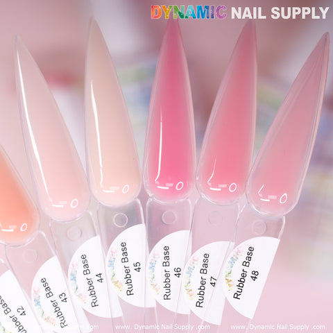 Close-up of nail color swatches in a gradient from light pink to peach, labeled with numbers 43 to 48. Each swatch is tagged as part of the BIAB Rubber Base Gel collection and arranged in a fan shape. The background is blurred, featuring the text Dynamic Nail Supply at the top, highlighting their Builder Gel in a Bottle collection numbered 40 to 48.