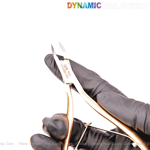 A gloved hand holds NT1223 - G09 4mm Professional Stainless Steel Cuticle Nippers against a white background.