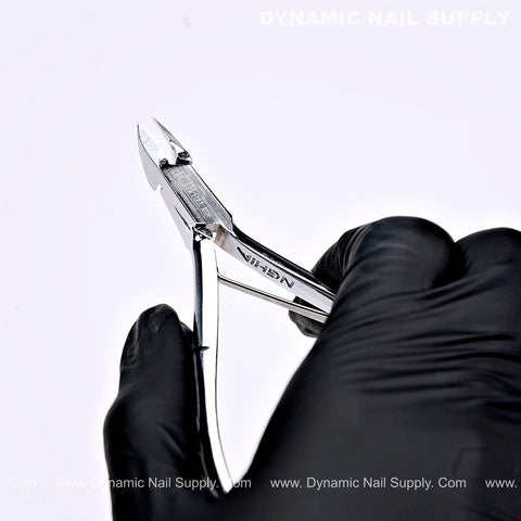 A gloved hand holds the D18 Sharp Cuticle Cutter—Professional Full Jaw—for precise dead skin trimming against a white background.