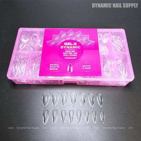 A pink box labeled Natural Stiletto (Medium) Full Cover Soft-Gel Tips with clear stiletto nails arranged in front.
