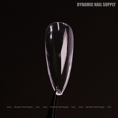A single Natural Stiletto (Medium) Soft-Gel Nail Tip is held by tweezers; Dynamic Nail Supply appears in the background.