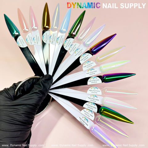 A hand in a black glove displays an array of fan-like nail polish swatches featuring captivating shades, including metallic green, gold, pink, purple, and ethereal tones, all created using the Light-Pearl Transparent Iridescent Chrome #12 - High Brightness Fine Pigment Powder. The name Dynamic Nail Supply appears prominently at the top in colorful letters.