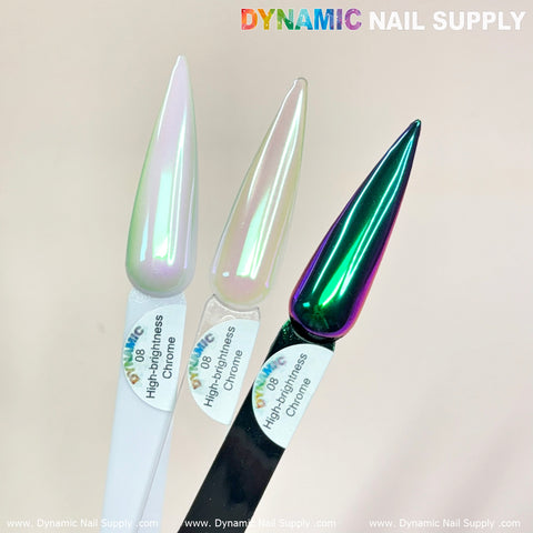 Three elongated nail tips display unique chrome finishes: one with a white subtle shimmer, an iridescent powder reflecting pink and green hues reminiscent of the Light-green/Purple/Mermaid Iridescent Chrome #08, and one with a metallic dark green sheen. Each tip is an embodiment of the stunning High-Brightness Chrome nails design from Dynamic Nail Supply. The watermark reads Dynamic Nail Supply.