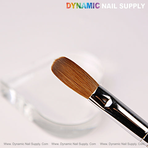 The [Crimped] Size 16 Dynamic Kolinsky Brush with silver handle hovers above a clear, heart-shaped dish.