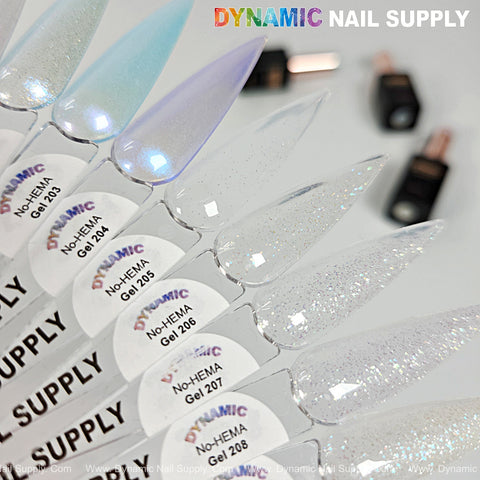 Pointed nail swatches in light blue and glitter shades of Dynamic No-HEMA Gel Polish 201–210; bottles blurred in background.
