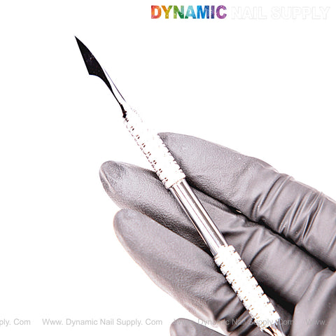 A gloved hand holds the NT1230 Professional Cuticle Pusher; Dynamic Nail Supply logo appears above.