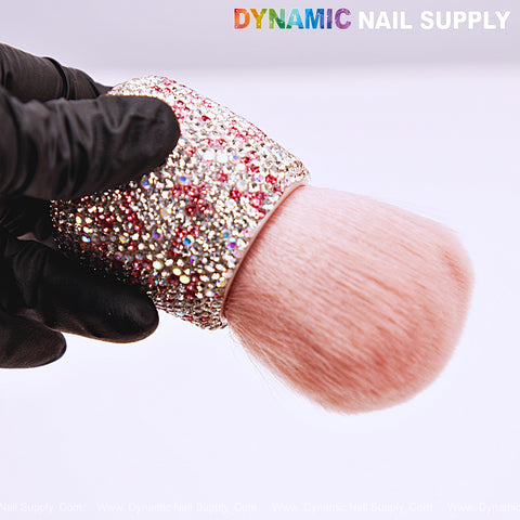 A black-gloved hand holds the AB-Pink Rhinestone Small Dust Brush; DYNAMIC NAIL SUPPLY at top.