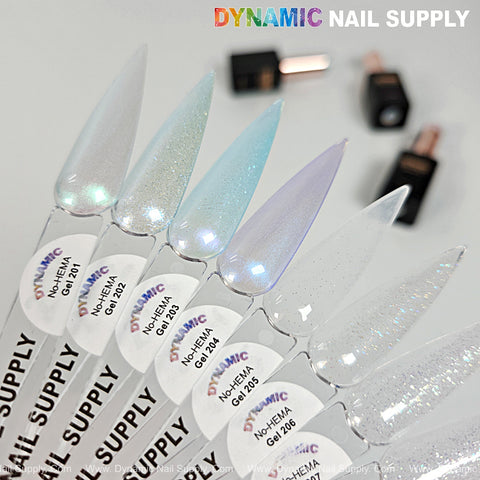 Eight long, pointed nails showcase shimmery Dynamic No-HEMA Gel Polish (Color 201–210); bottles blurred behind.