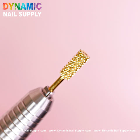 A close-up of the 2XC Double Extra Coarse Drill Bit - Small Barrel Carbide in gold tungsten carbide, attached to a metallic handpiece against a pink background. The Dynamic Nail Supply branding is prominently displayed in colorful text at the top left. The spiral pattern and double extra coarse design make it ideal for removing gel or acrylic nails.