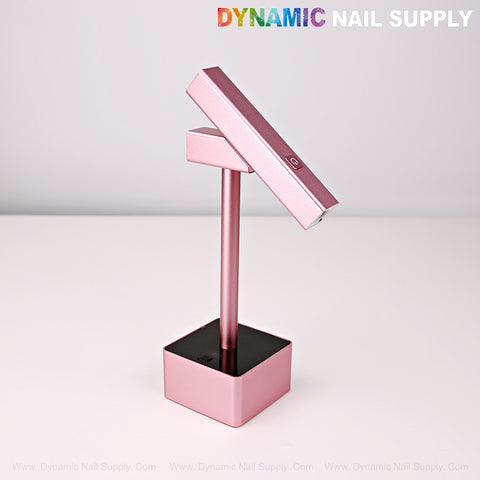 The 2 in 1 Mini UV/LED Flash Cure Lamp with stand sits on a white surface, branded by Dynamic Nail Supply.
