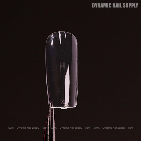 A clear Sculpted Square (Medium) Full Cover Soft-Gel Nail Tip held by tweezers, black box shown with branding.