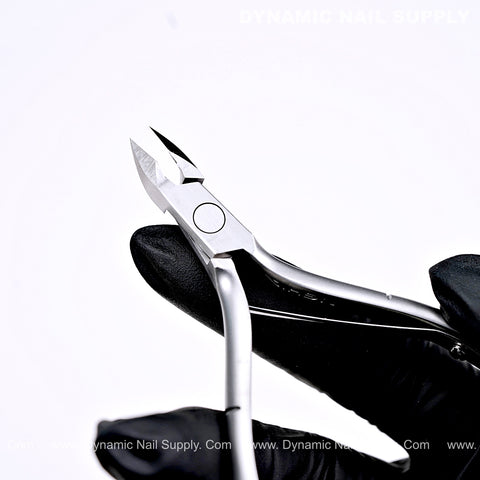 A gloved hand holds D09 - Jaw 14 Cuticle Clippers with Grip Control, perfect for clean cuticle removal.