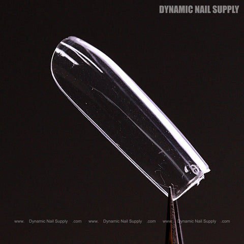 A clear Sculpted Square (Long) Full Cover Soft-Gel Nail Tip held by tweezers; DYNAMIC NAIL SUPPLY in corner.