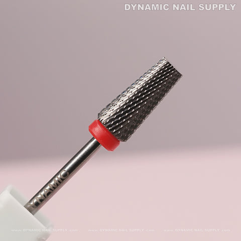 Close-up of 5-in-1 Fine Silver Tapered Flat-Top Carbide Nail Drill Bit with red band on pink background.