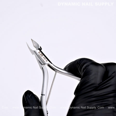 A gloved hand holds the D09 Jaw 16 Heavy-Duty Surgical Steel Cuticle Nipper by Dynamic Nail Supply against a white backdrop.