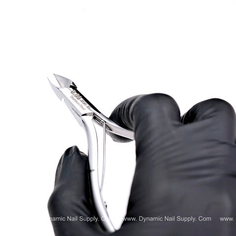 A hand in a black glove holds the D09 Heavy-Duty Cuticle Nipper, surgical steel, against a plain white background.
