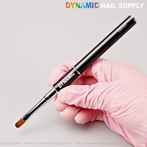 Hand in a pink glove holds the [Silver Black] Dual Head Gel Nail Brush—Oval and 15mm Liner—against a light background.