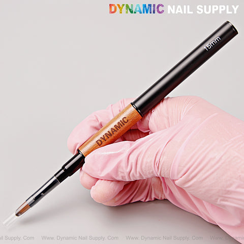 A gloved hand holds the Wood and Black Builder Gel Dual Head Brush with 15mm liner for gel nails, Dynamic Nail Supply text above.