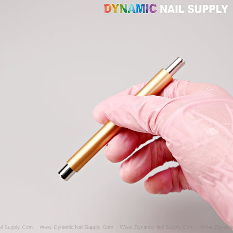 A gloved hand holds a Gold Dual Head Strong Cat Eye Magnet; DYNAMIC NAIL SUPPLY is at the top right.