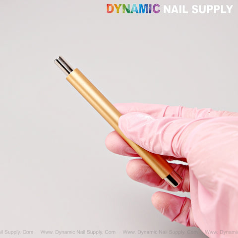 A gloved hand holds the Gold Dual Head Strong Cat Eye Magnet tool. DYNAMIC NAIL SUPPLY text is at the top right.