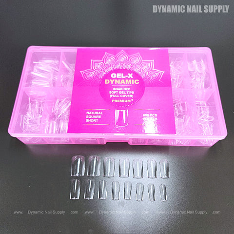 A pink box labeled Natural Square (Short) holds full cover soft-gel nail tips; several tips are arranged in front.