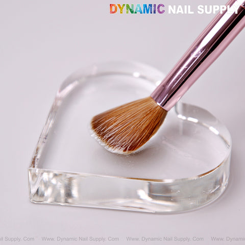 The Dynamic Metallic Pink Kolinsky Nail Brush rests on a clear heart palette; DYNAMIC NAIL SUPPLY is above in colorful text.
