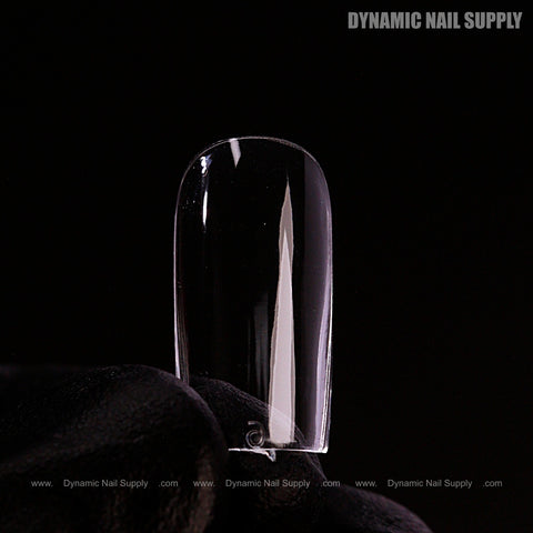 A gloved hand holds a Natural Square (Short) Full Cover Soft-Gel Nail Tip (Pink Box) against a black background.