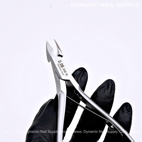 A black-gloved hand holds D06 - Jaw 16 Nail Nippers, a pro cuticle cutter ideal for salon or home manicure and pedicure.