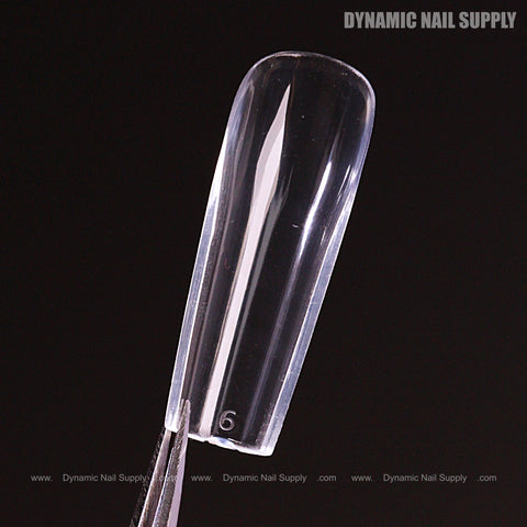 A Natural Square (Long) Soft-Gel Nail Tip is held by tweezers against black, with 6 embossed at the base.