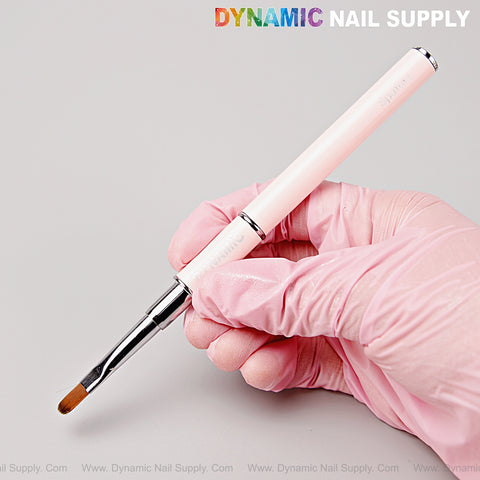 A gloved hand holds the [Silver Pink] Builder Poly Hard Gel Dual Head Oval Brush & Spatula under DYNAMIC NAIL SUPPLY text.